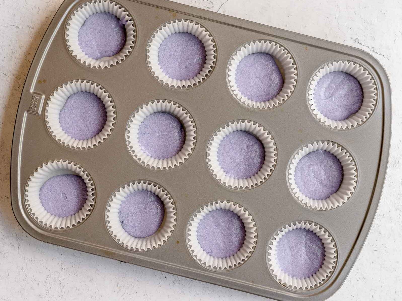 Unicorn Cupcakes purple batter layer in cupcake pan.