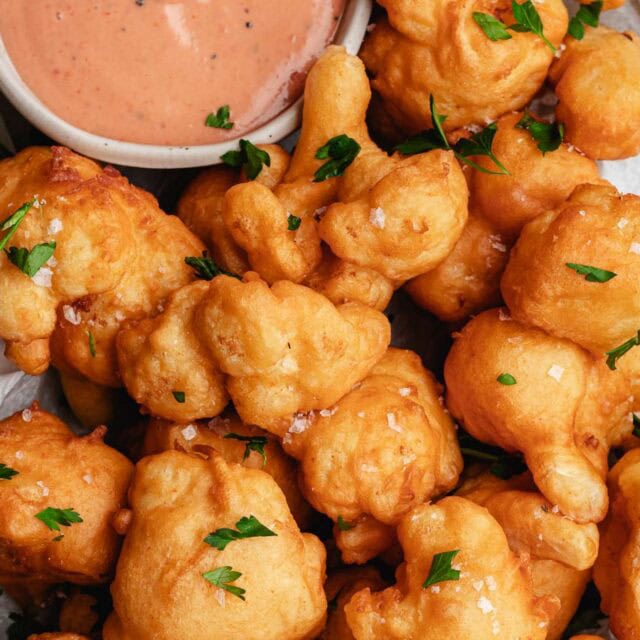 Serving dish of fried cauliflower with dipping sauce.