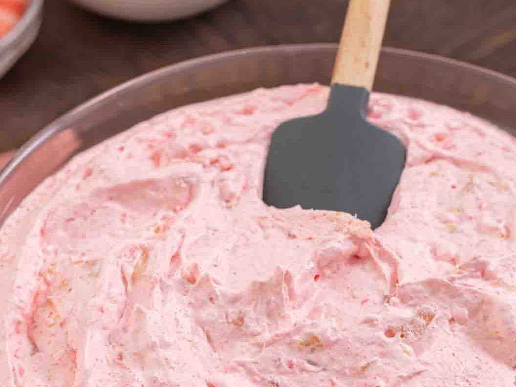 Dessert ingredients in a mixing bowl being mixed with a spatula