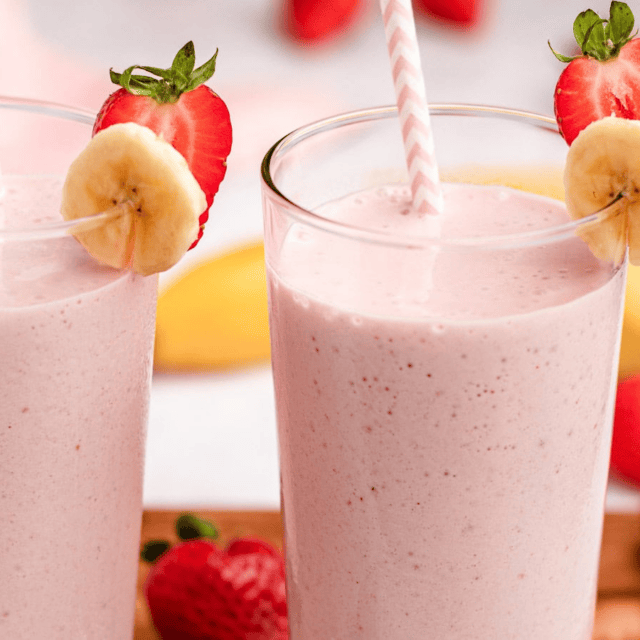 smoothies in glasses with strawberry and banana garnish