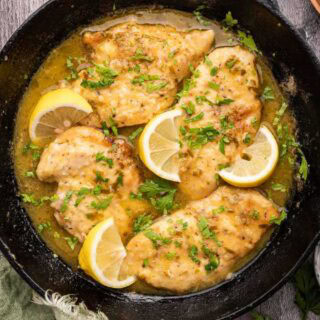 Cutlets with a lemony sauce in cast iron pan.