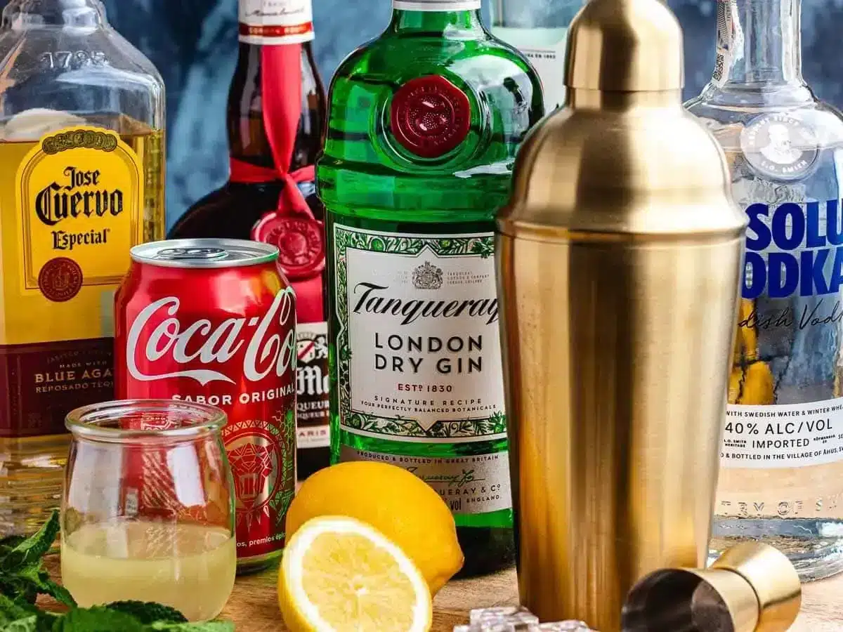 several alcohol bottles with drinks and lemons