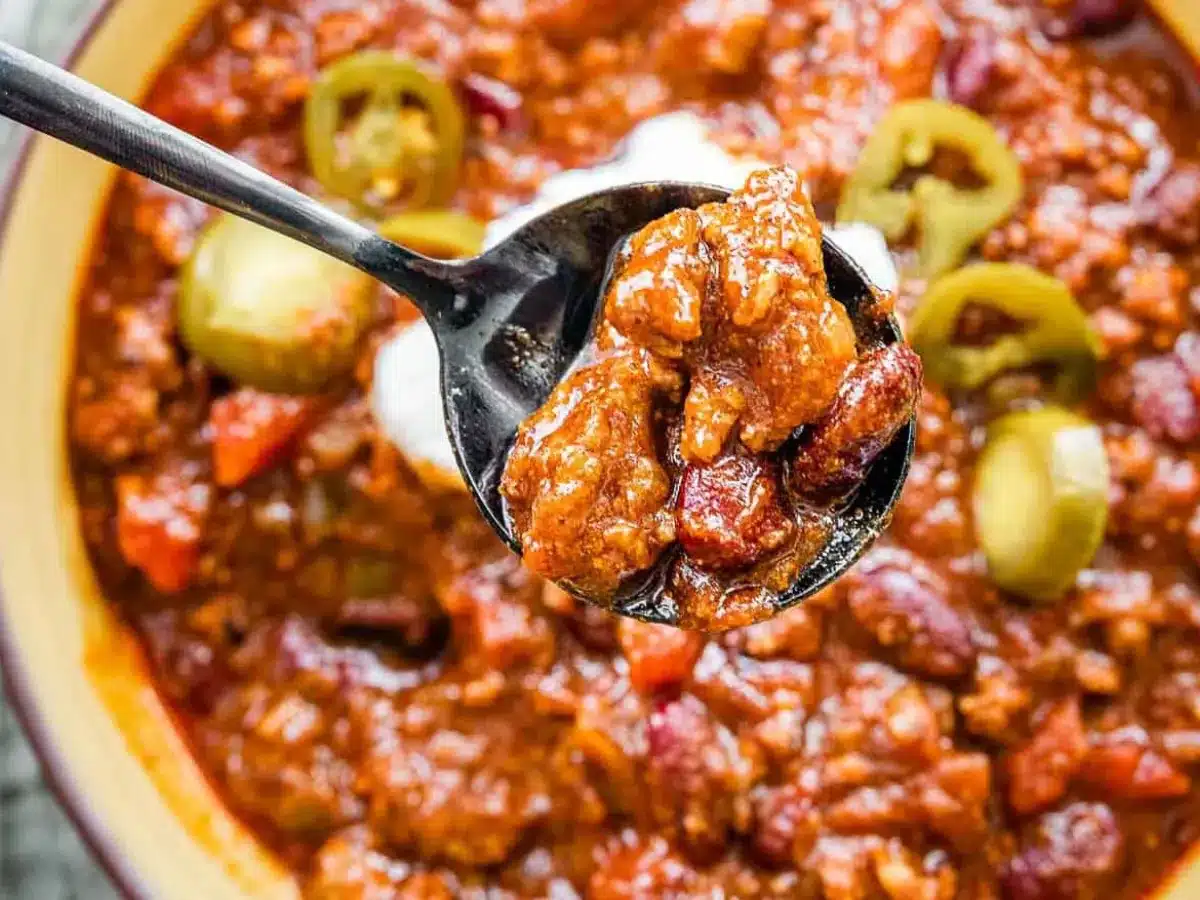 Spoon scooping chili out of bowl
