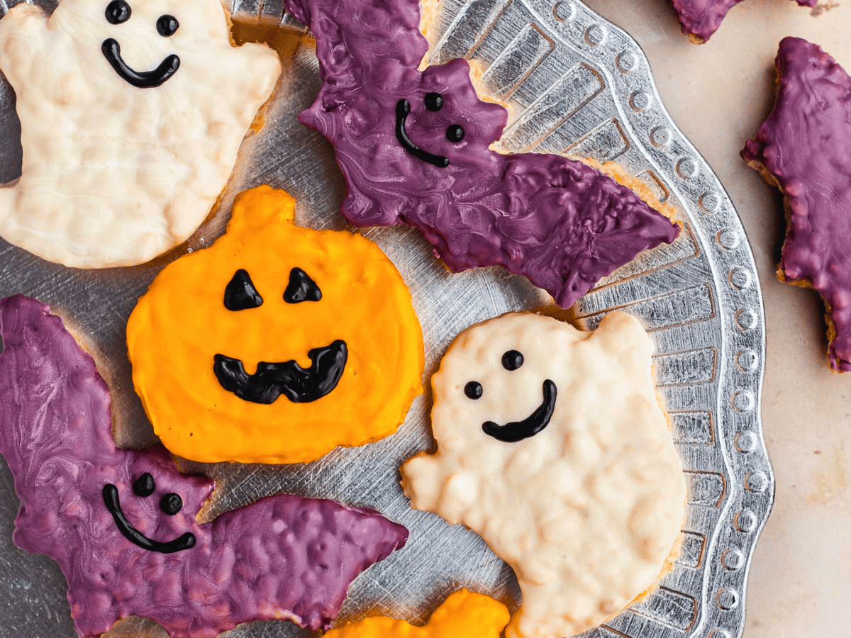 pumpkin, bat, and ghost-shaped cookies on a platter