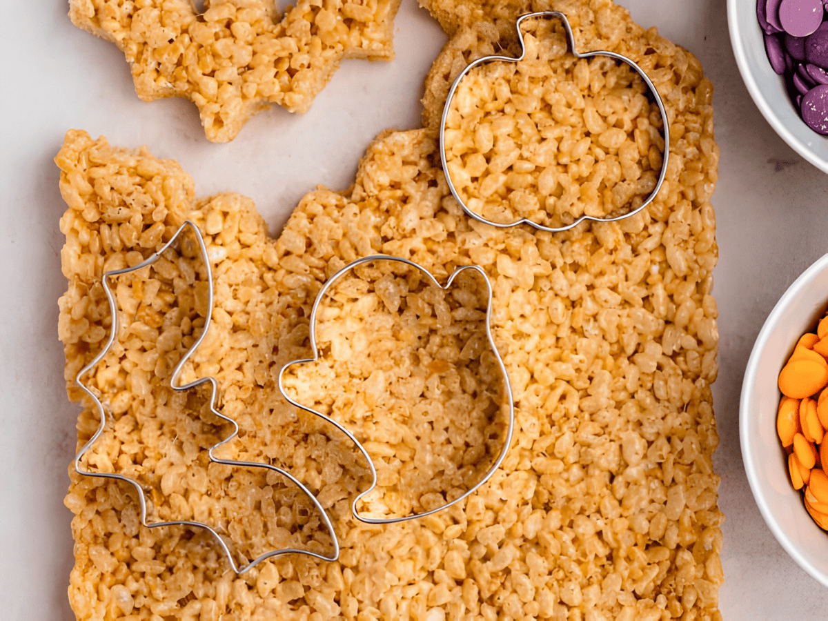 pumpkin, ghost, and bat cookie cutters on top of rice krispies