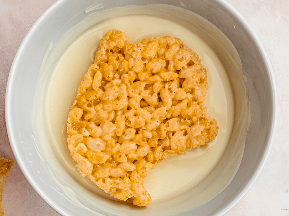 ghost rice krispie in a bowl of melted white chocolate