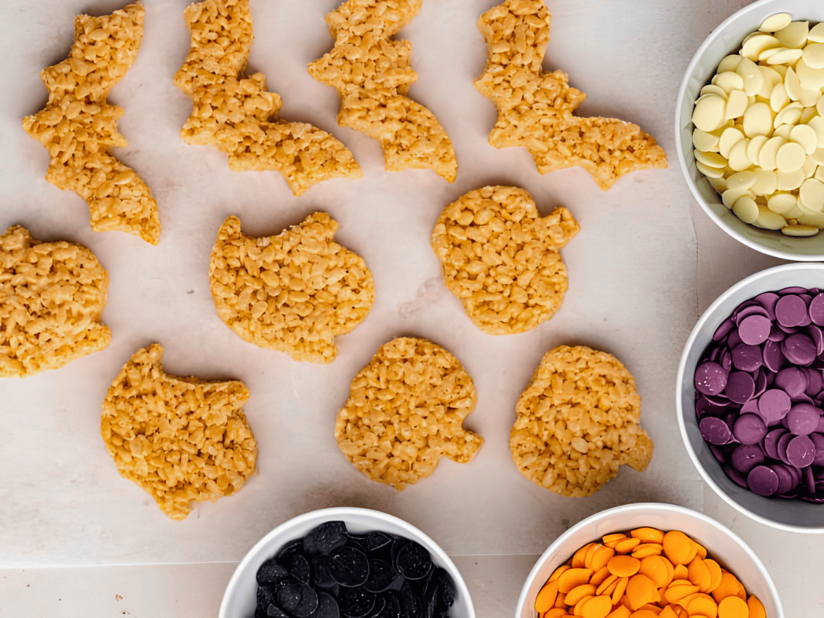 Rice Krispies cut into bats, pumpkins, and ghosts with colored chocolates in separate bowls