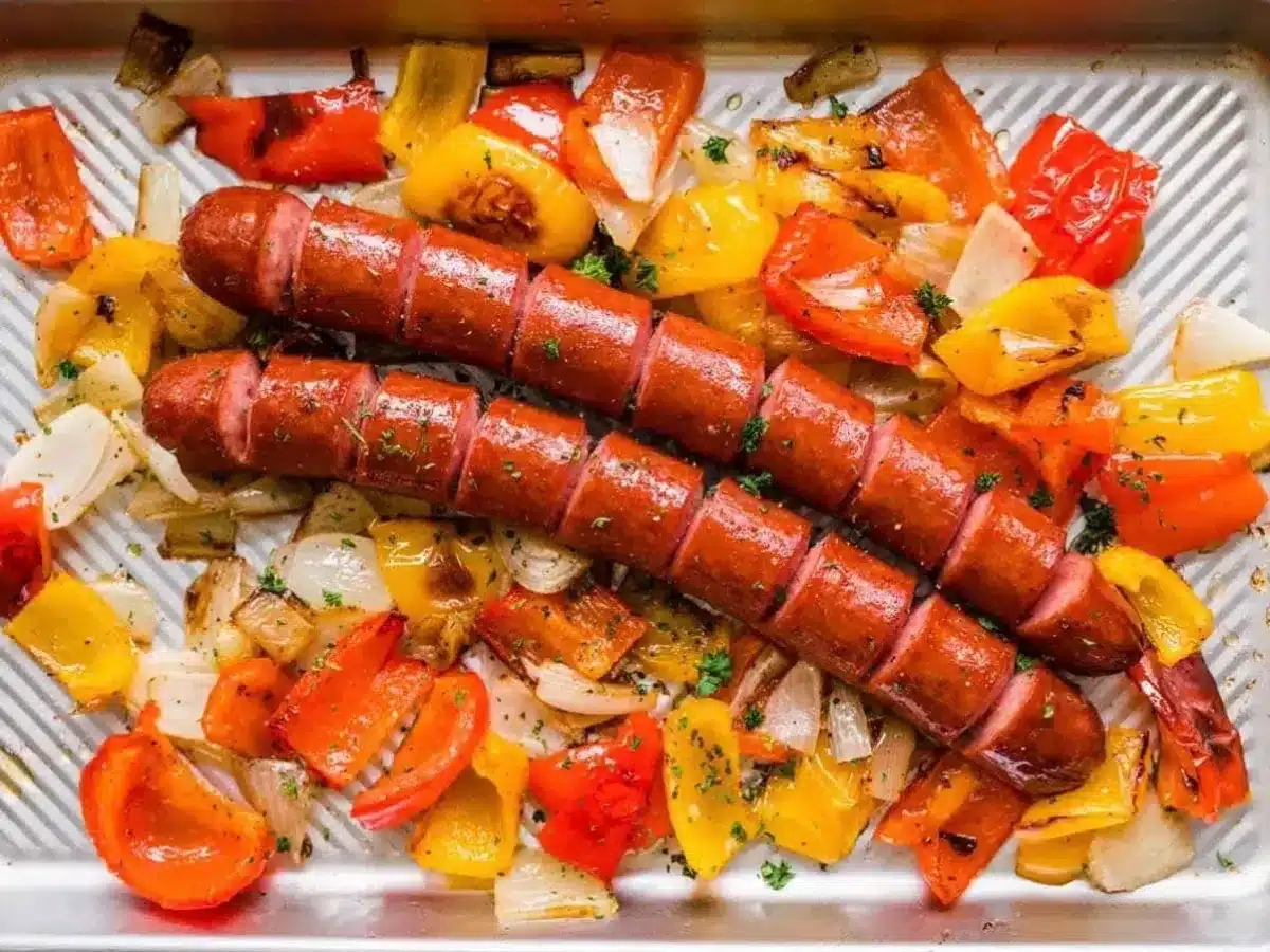 cooked sausage, peppers and onions on a sheet pan