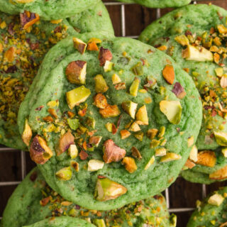 Close up of green cookie, topped with pistachios.