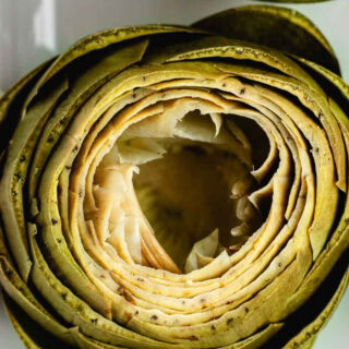Artichoke that is cooked and ready to eat.