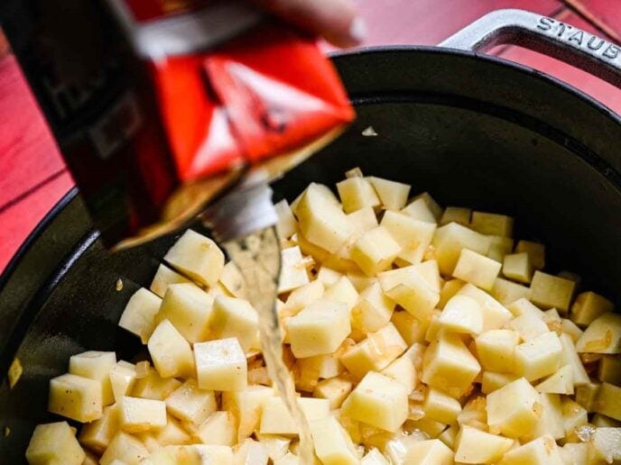 Pouring broth over potatoes