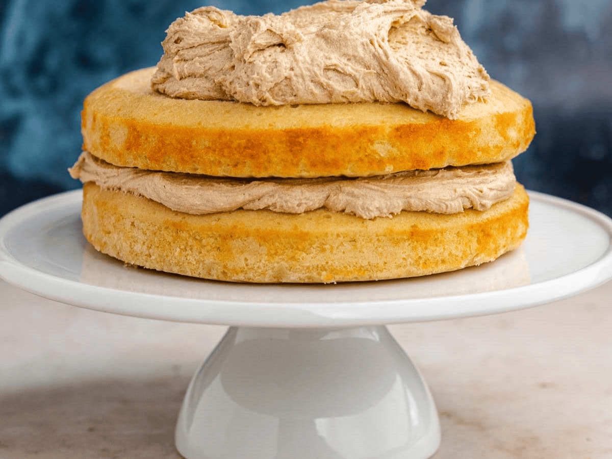 Frosting vanilla cake on a cake stand