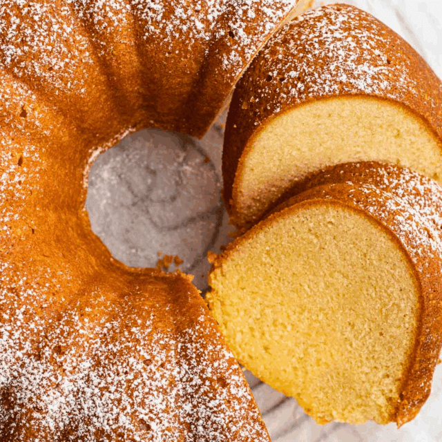 Baked Bundt cake plated with slices cut and dusted with sugar