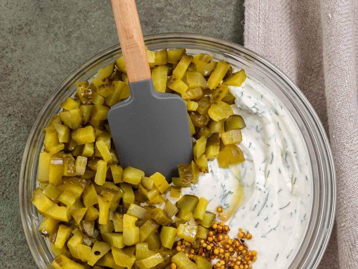 pickles and cream mixture in a bowl with spatula