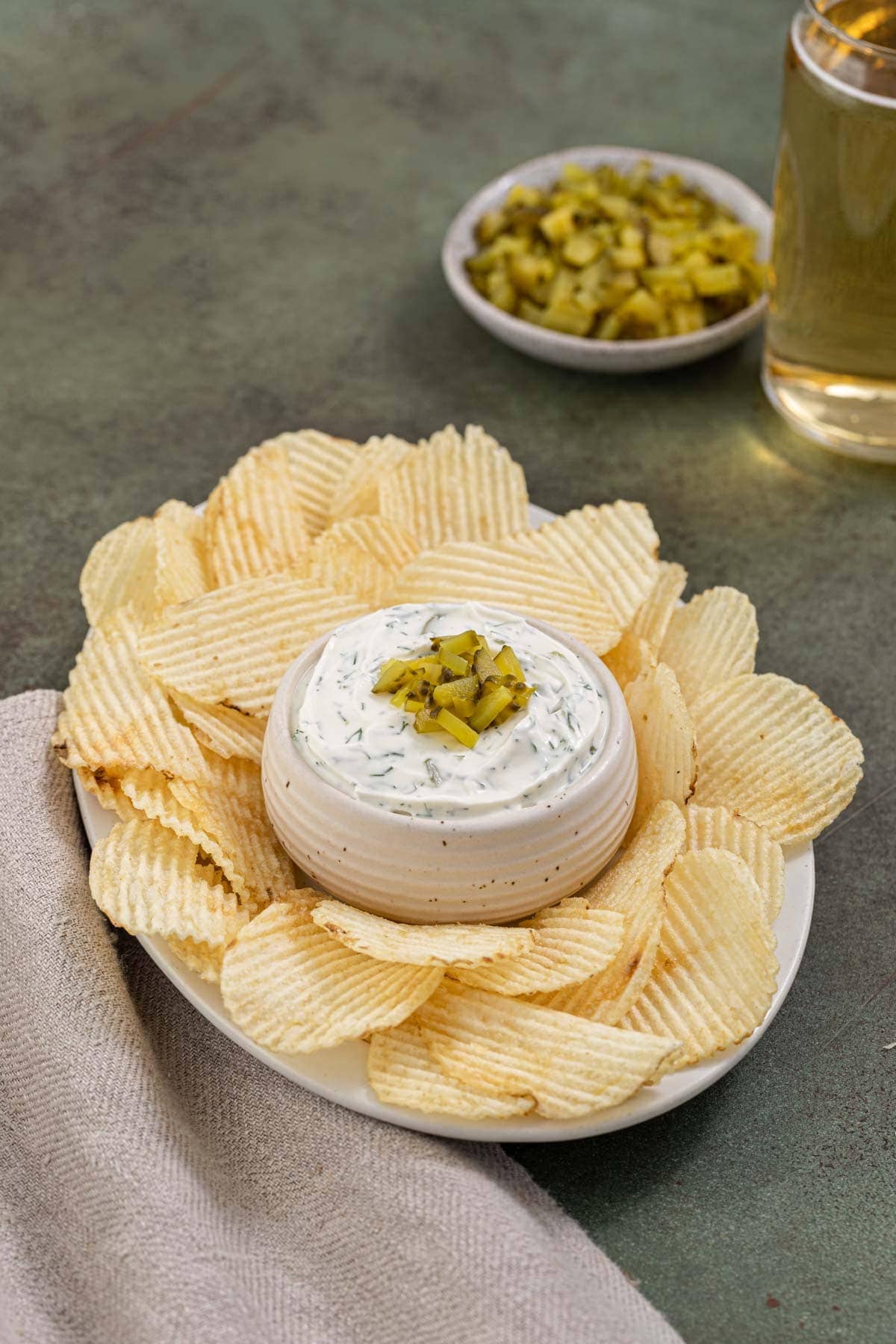 Bowl of dip surrounded by chips on a platter