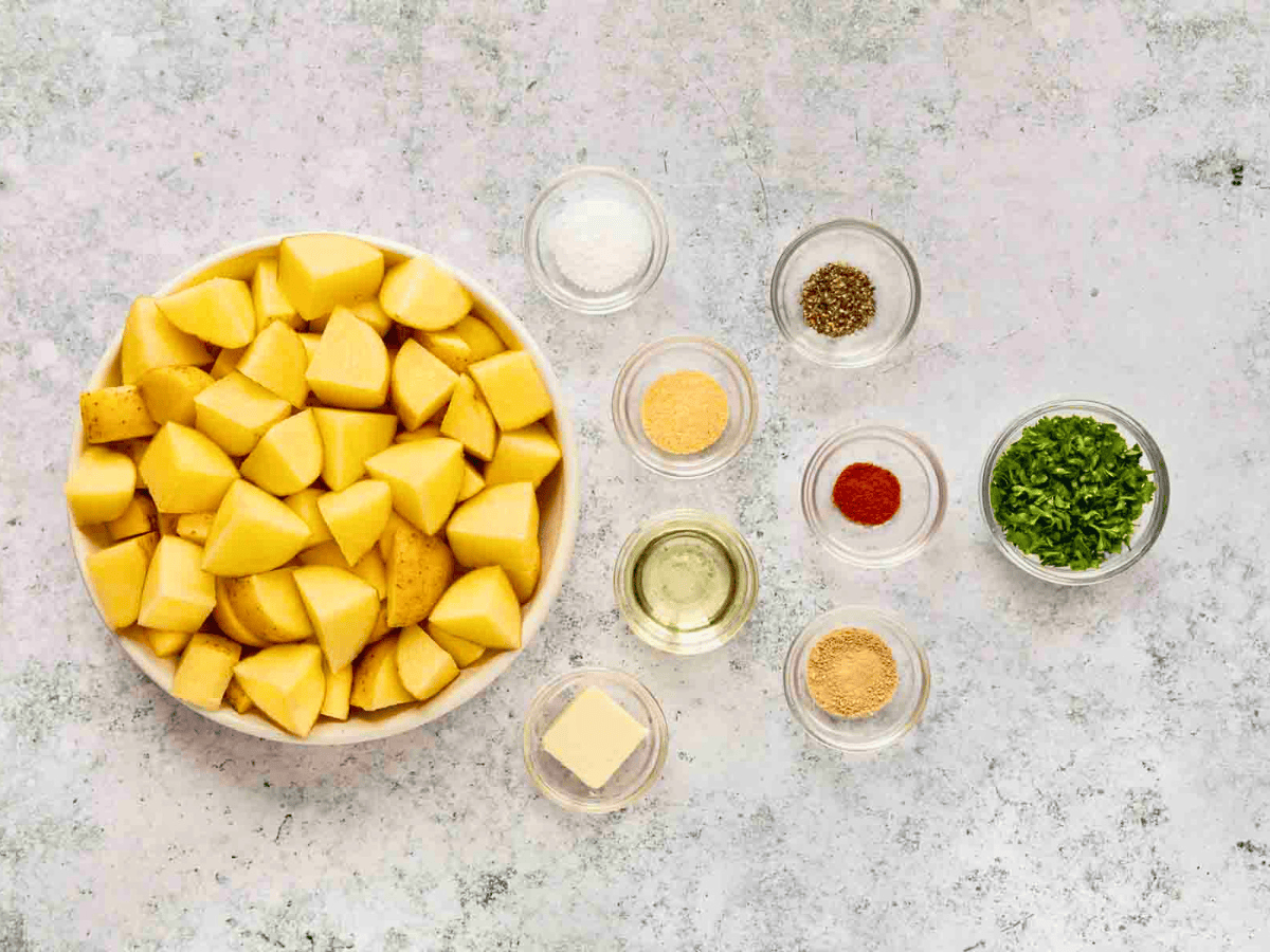 spices and seasonings in glass bowls, and potatoes in a big bowl