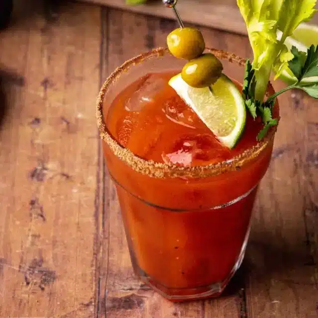 Glass filled with tomato juice, rimmed with celery salt, and garnished.