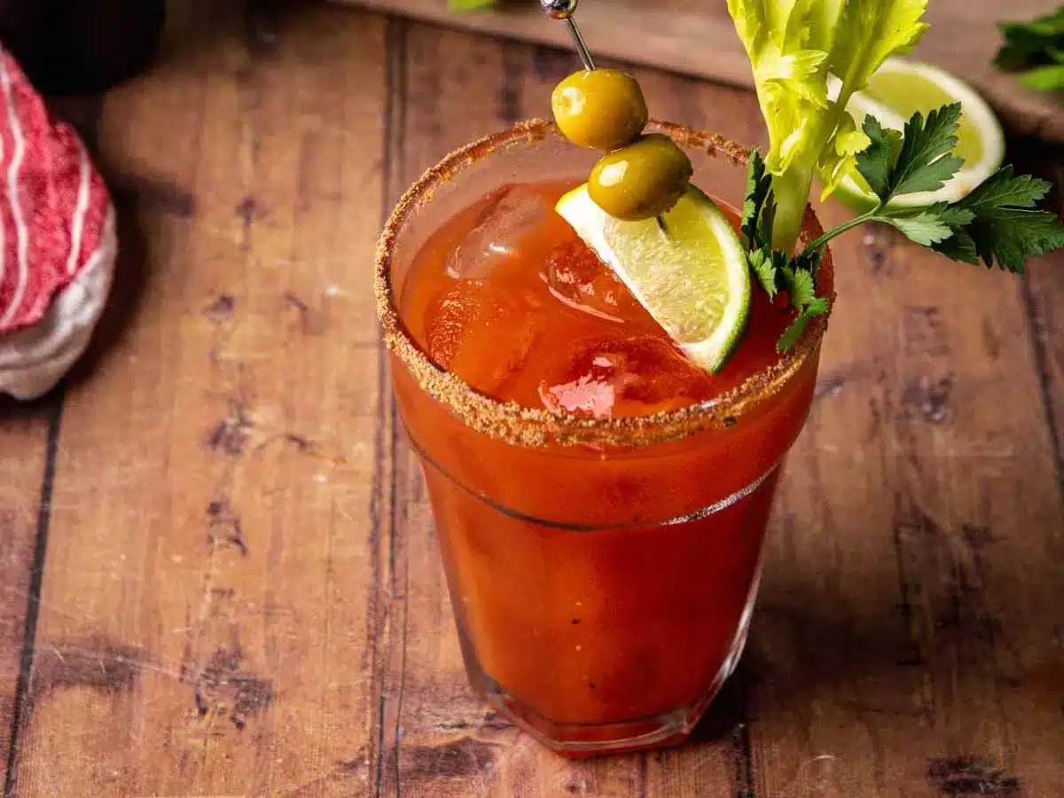 Glass filled with tomato juice, rimmed with celery salt, and garnished.