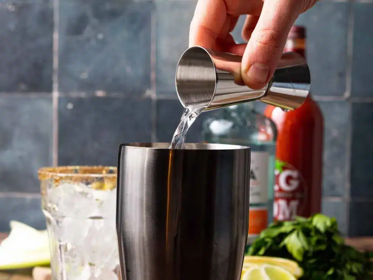 Vodka being poured into cocktail shaker.