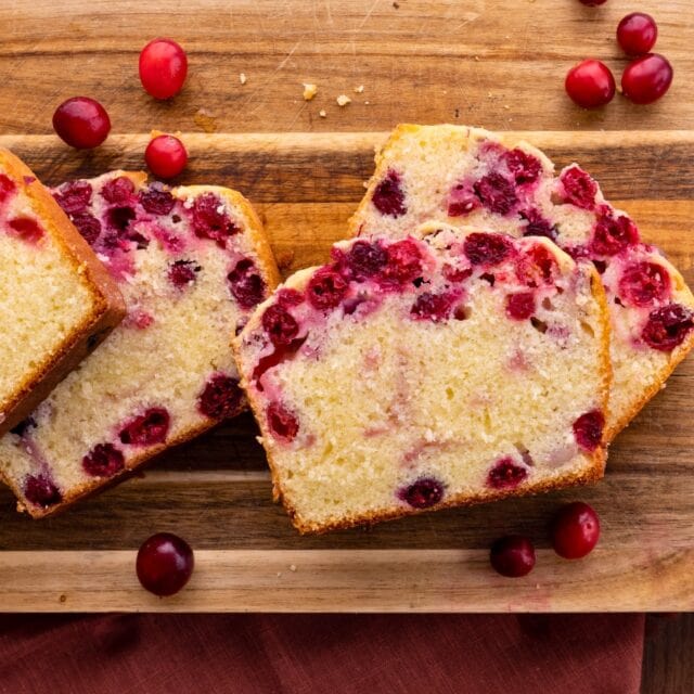 bread slices and cranberries on a cutting board