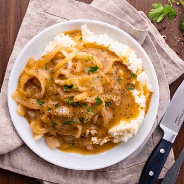 Cubed Steak and Gravy over a plate of mashed potatoes