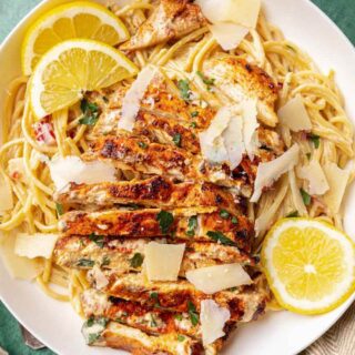 Dinner plate with creamy spaghetti, chicken, and lemon garnish 4x3