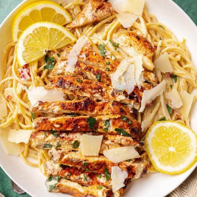 Dinner plate with creamy spaghetti, chicken, and lemon garnish 4x3