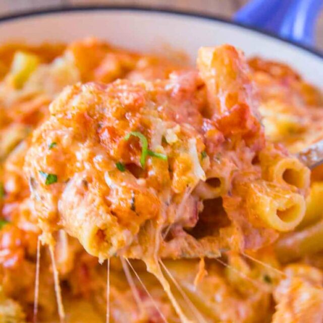 Cooked pasta in bowl with bite on fork.