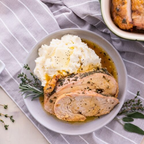 Sliced turkey on a plate with mashed potatoes