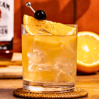Finished cocktail in short glass with ice and garnish