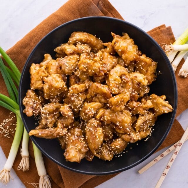 Fried chicken pieces on a black plate