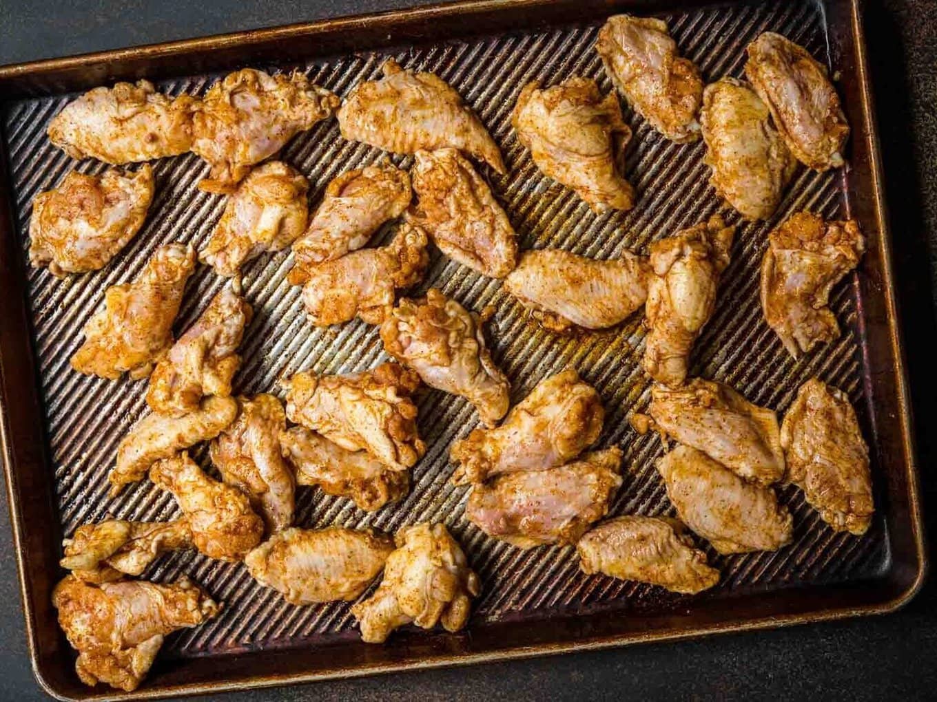 Baked Chicken Wings seasoned chicken wings on baking sheet before baking