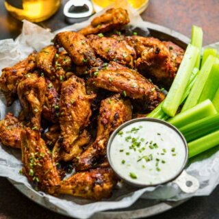 Cooked wings in a basket with ranch and celery sticks