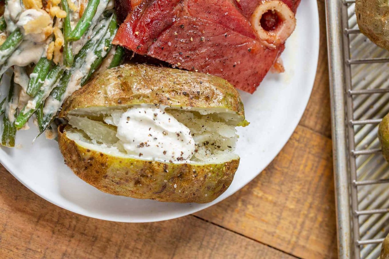 Baked Potatoes every time for crispy outside tender inside potatoes. #dinner #sidedish #potato #bakedpotato #dinnerthendessert Baked Potato with sour cream on plate
