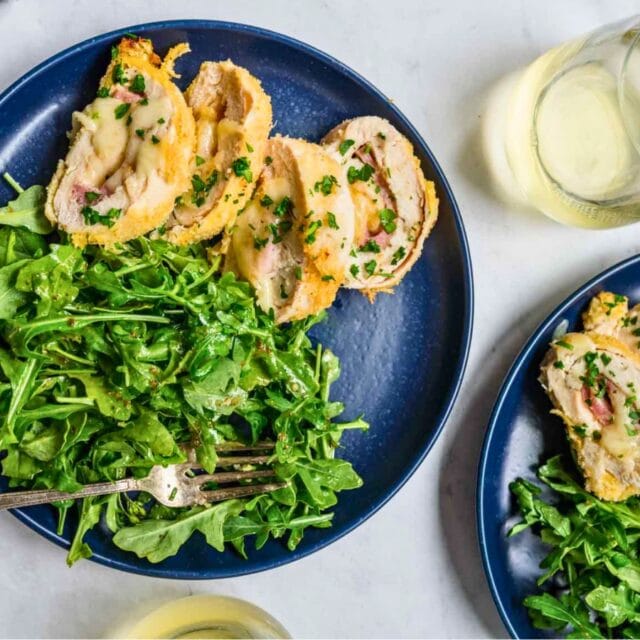 Cooked chicken slices with greens on a plate
