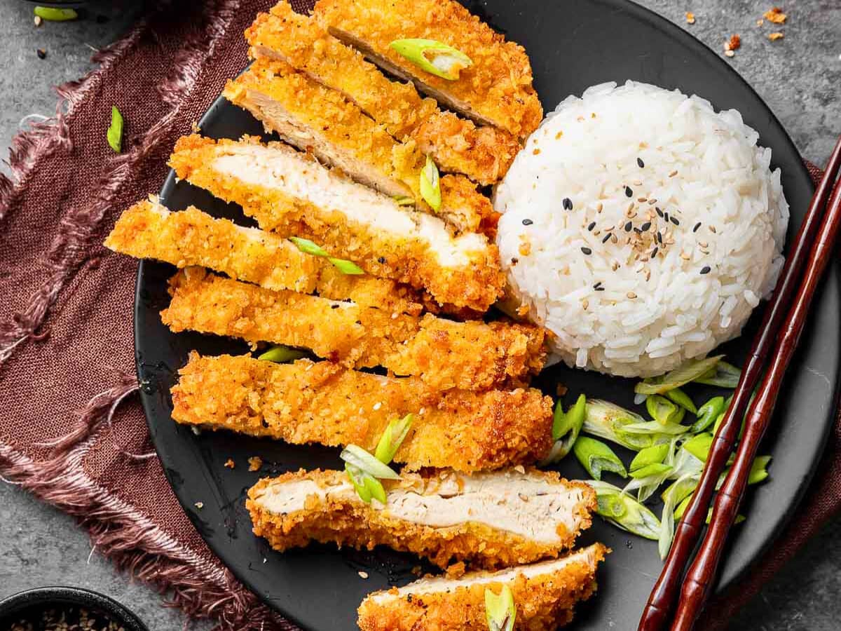 Sliced Chicken cutlets on a plate with rice