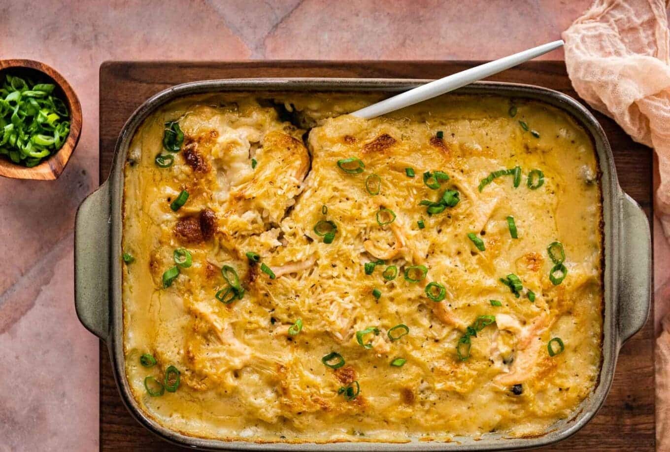 Large dish of baked casserole with a serving spoon