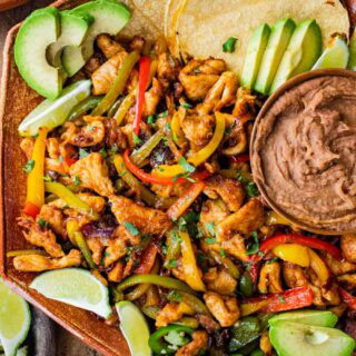 Plate of chicken fajitas with toppings and tortillas