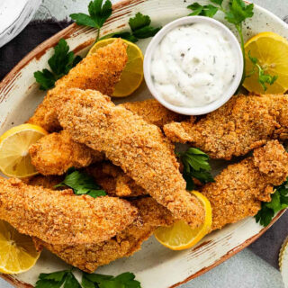 Platter of fried fish sticks with bowl of tartar sauce