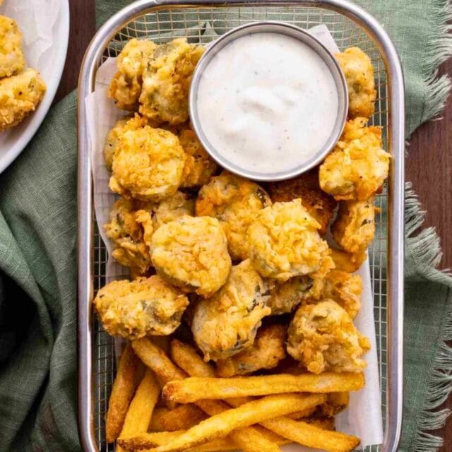 Fried pickles in a basket with fries and ranch