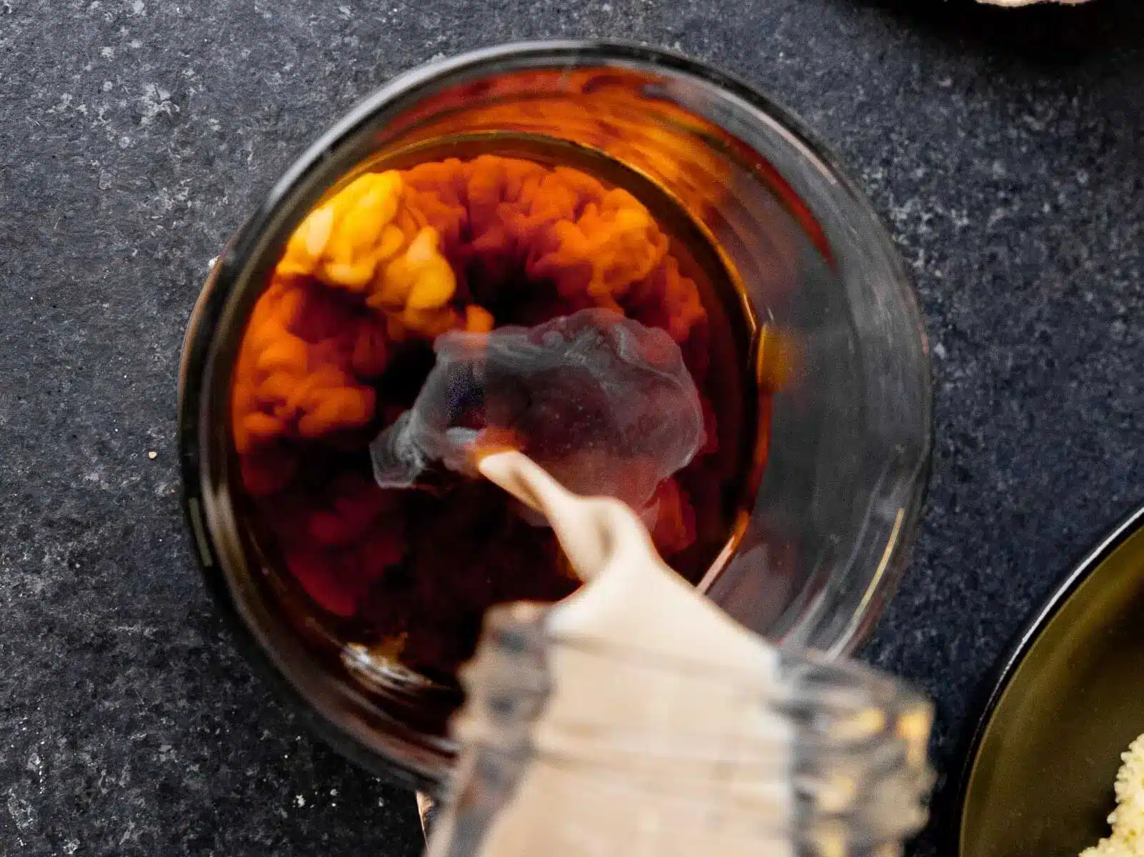 pouring creamer into coffee 