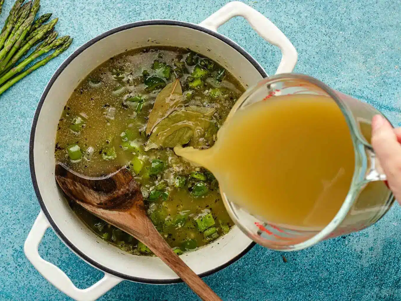 adding broth to soup