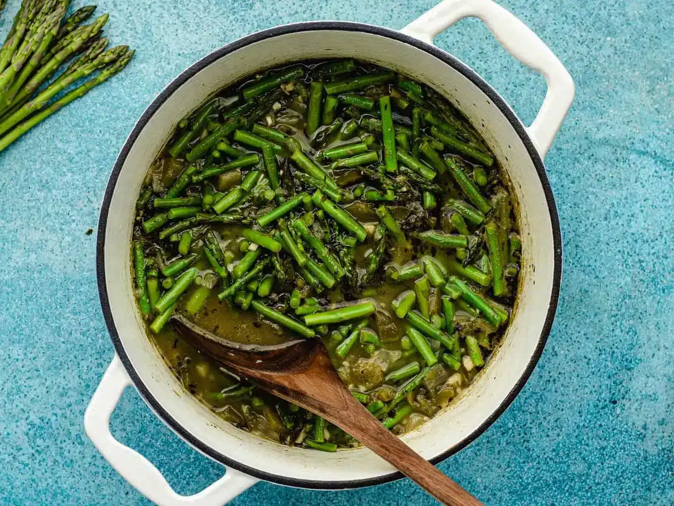 adding asparagus to the soup