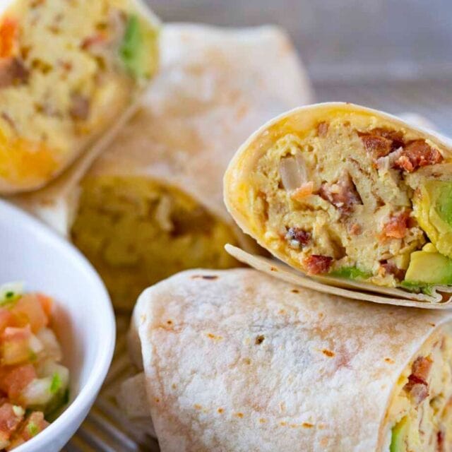 Halved burritos on a platter with pico de gallo