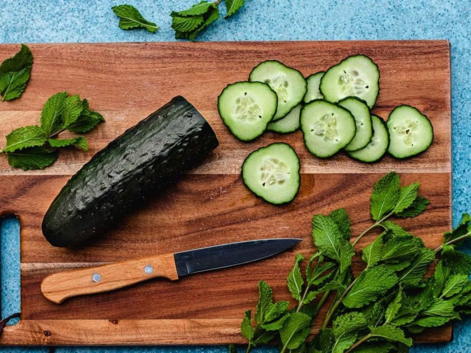 Cucumber half sliced on wooden board