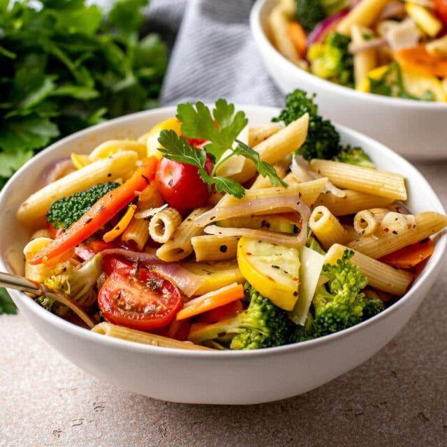 Prepared pasta in bowl with parsley and cheese garnish