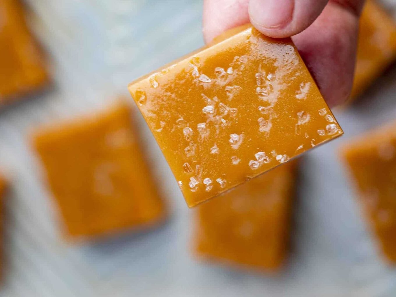 hand holding caramel candy square 