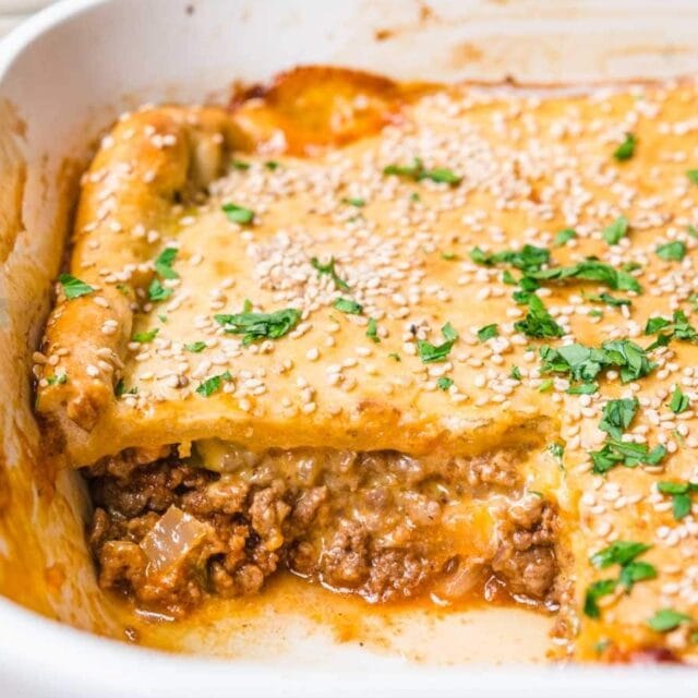 Baked casserole in baking dish with slice removed