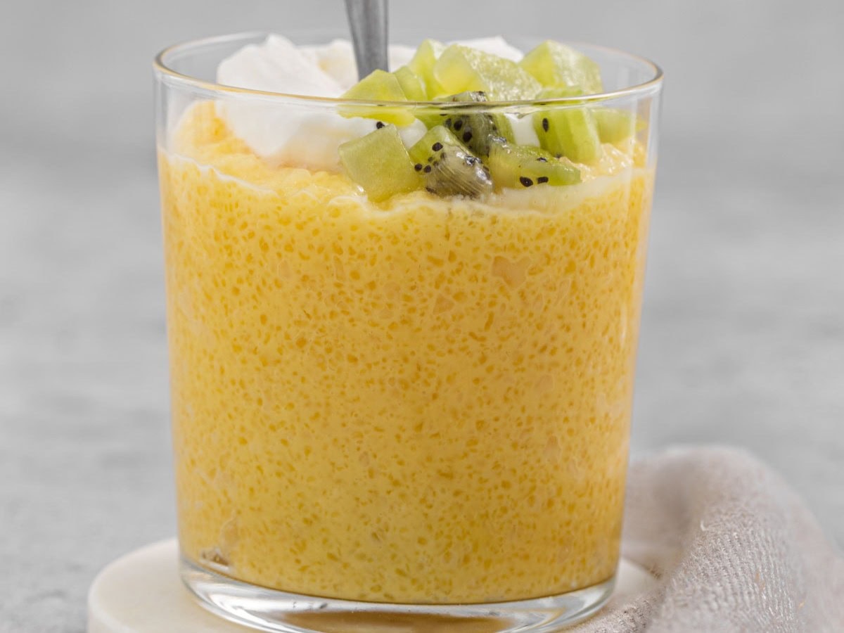 Tapioca Pudding is a classic and comforting dessert dish that you can make with milk, butter, sugar, eggs, vanilla extract, and tapioca. Tapioca Pudding in a glass with garnishes and a spoon