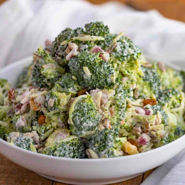 Dressed salad with raisins in a white bowl